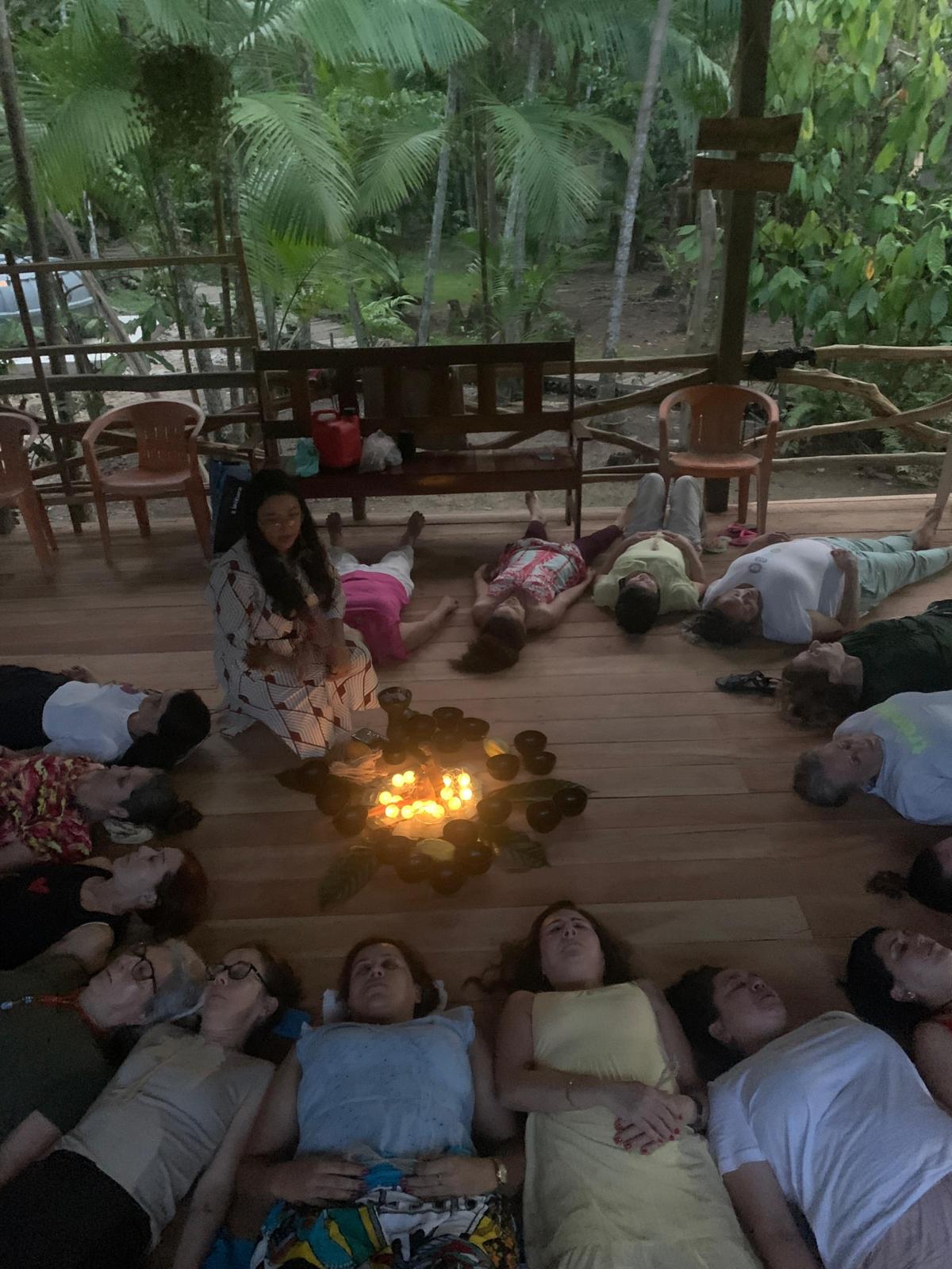 Meditação noturna em círculo com velas